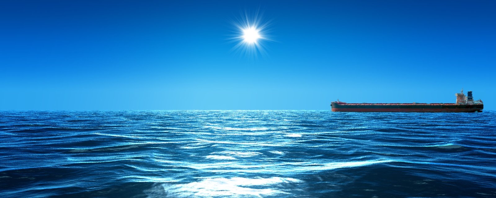 A bulk carrier under way on open water beneath a clear sky