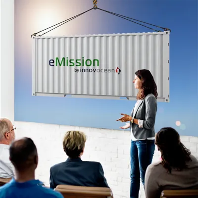 An eMission branded shipping container suspended above a seated audience during a presentation.